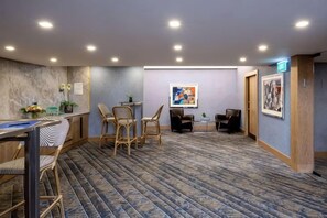 Vestíbulo de hotel con recepción, zona de estar y suelo alfombrado.