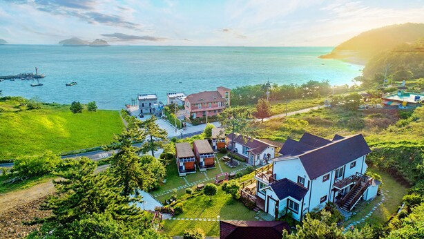 A coastal residential area with houses, a marina, and a view of the sea.