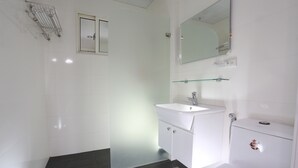 A modern bathroom with a white sink, a glass shower enclosure, and a toilet. - Guo Chen Hotel (Luodong)