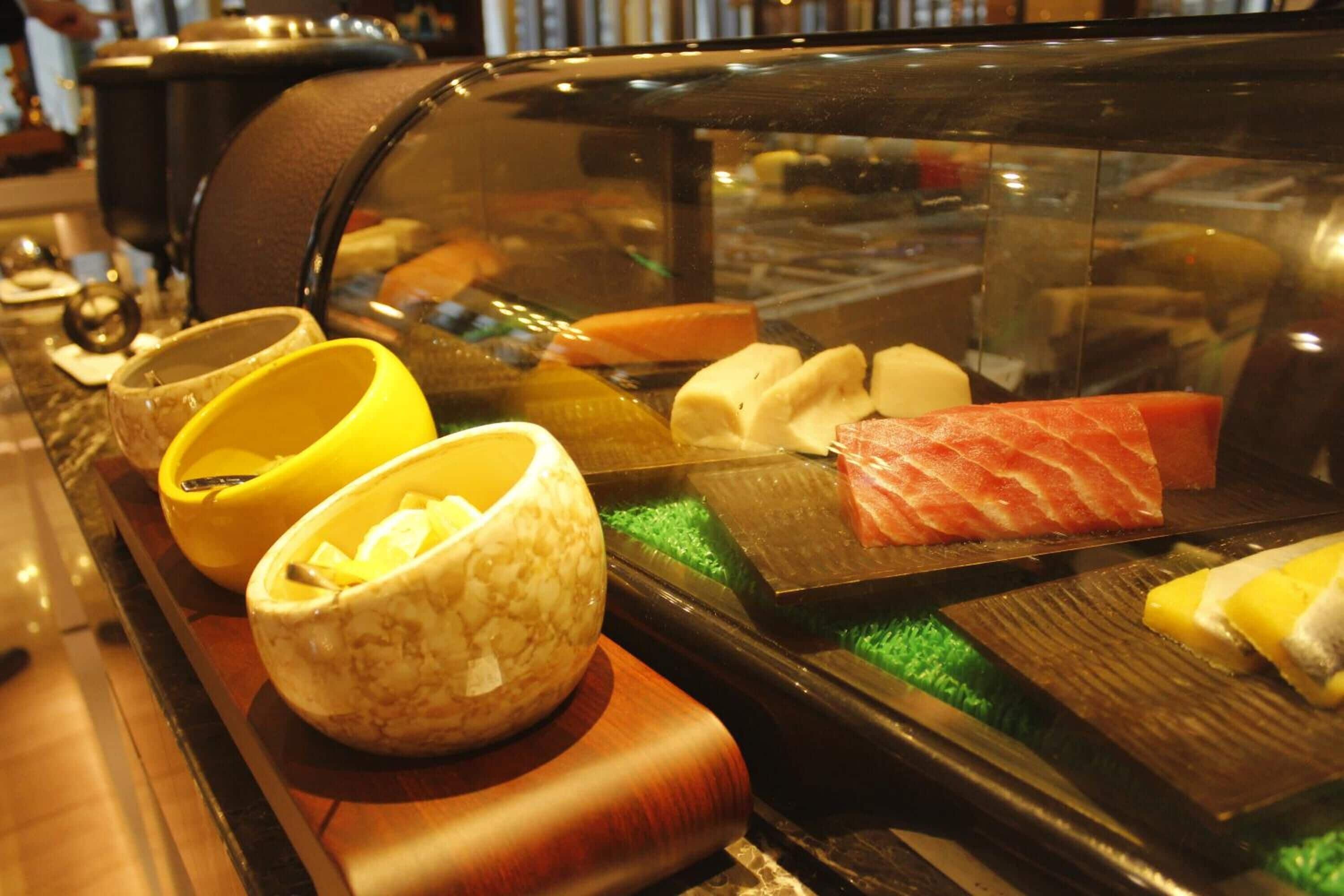 A sushi bar with various types of sushi and condiments.