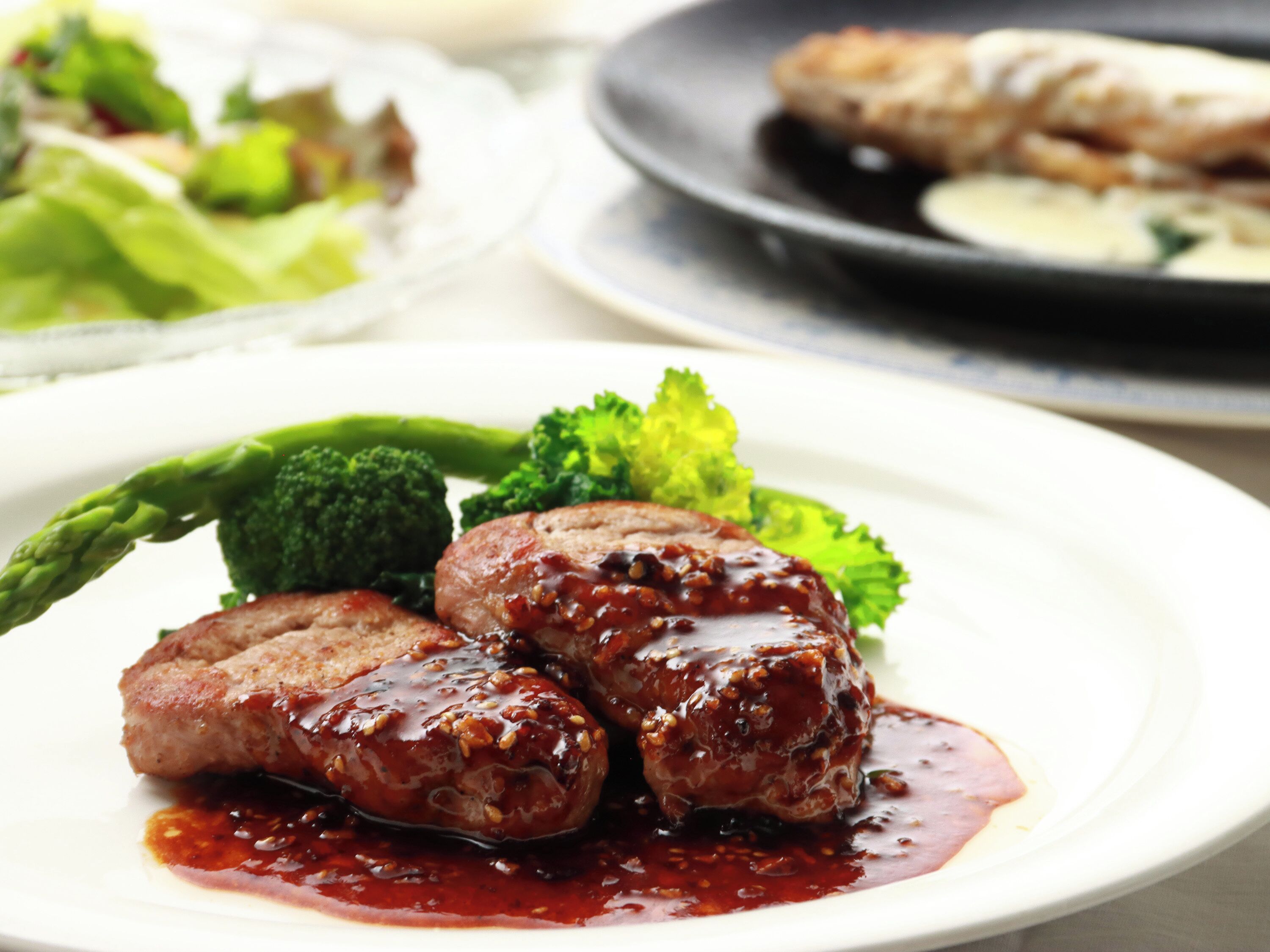 A plate with glazed meat and vegetables.
