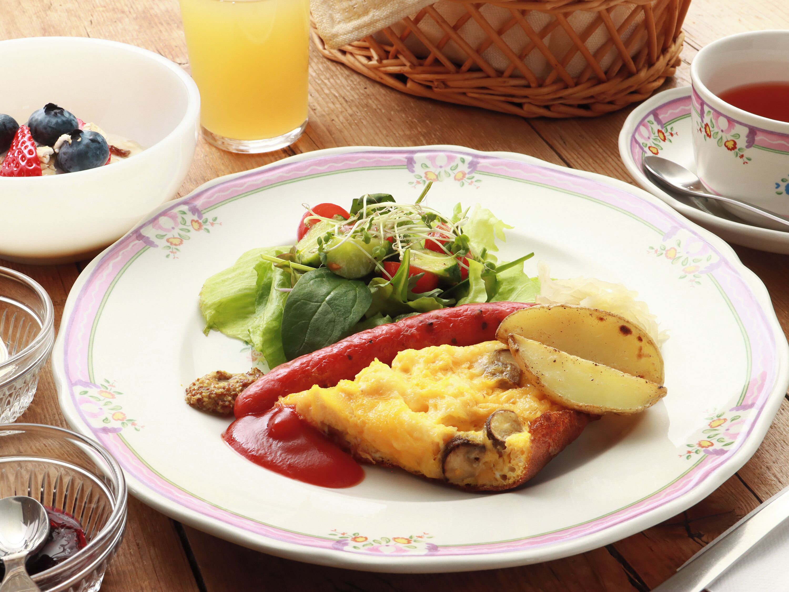 A plate with a salad, a slice of egg, and a red pepper.