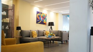 A modern living room with a sofa, armchairs, a coffee table, and a colorful painting on the wall. - B Residence (Beirut)
