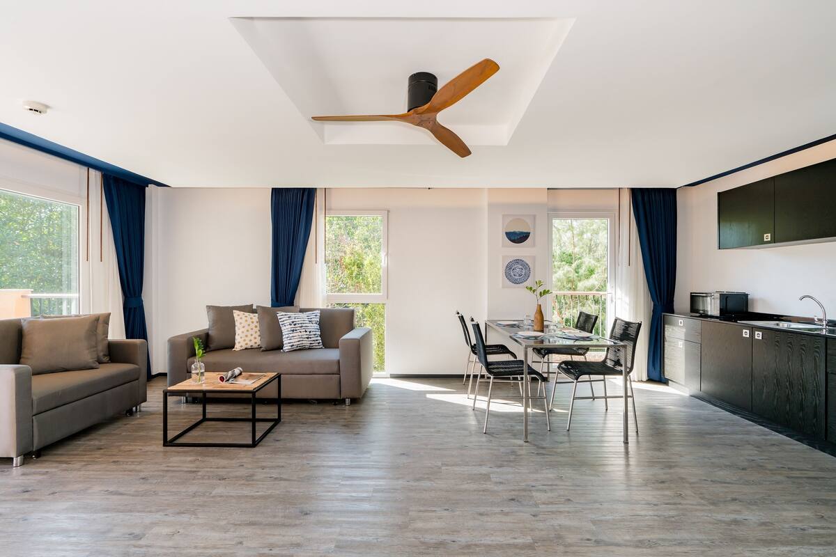 A modern living room with a sofa, coffee table, and dining area.