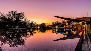 Una piscina al aire libre, sombrillas, tumbonas
