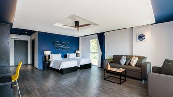 A modern hotel room with a large bed, a sofa, a desk, and a chair.