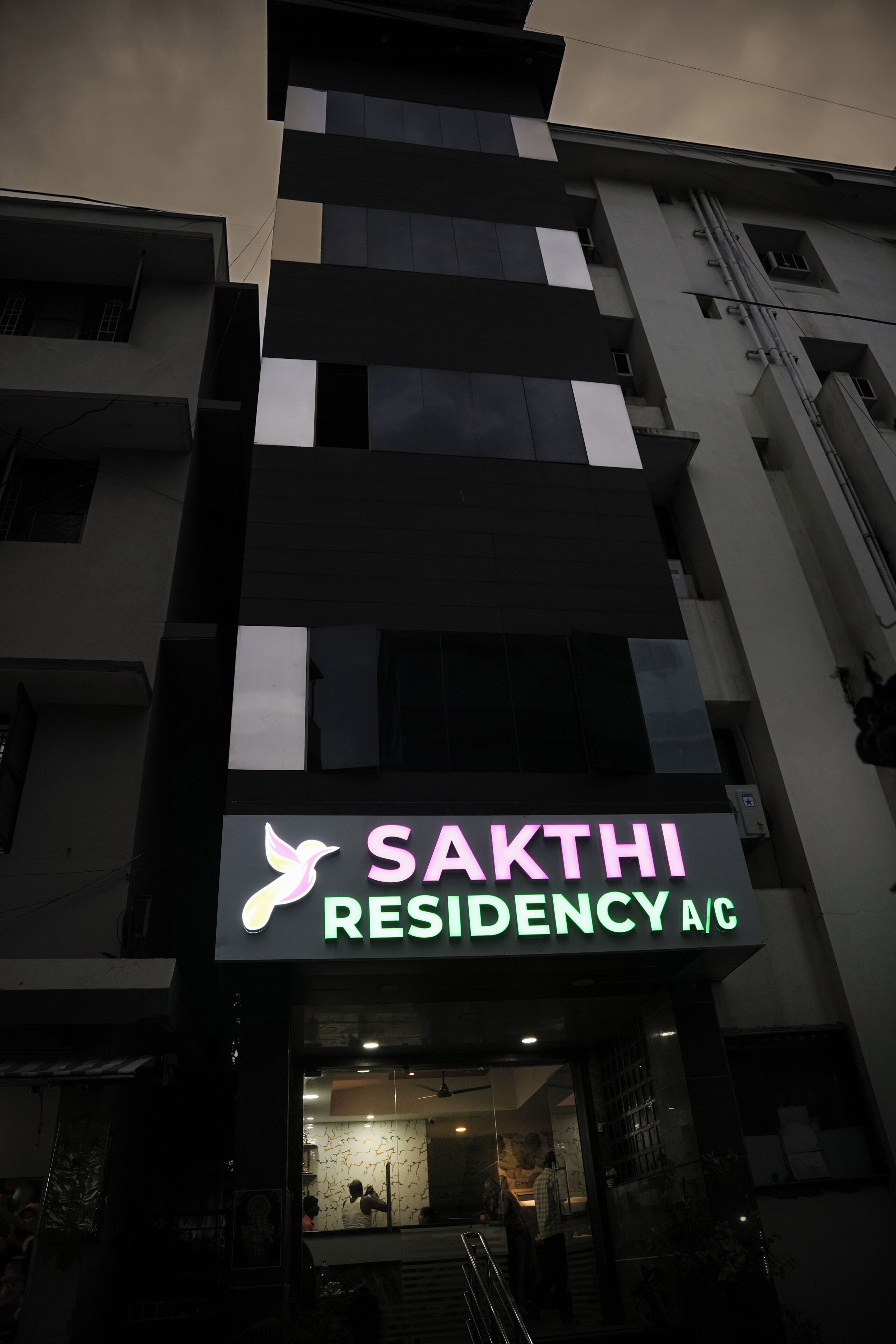 A building with a sign for 'SAKTHI RESIDENCY A/C'.