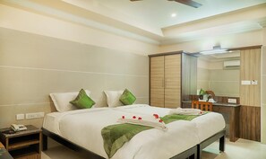 A hotel room with a large bed, a desk, and a wardrobe. - Sakthi Residency (Kumbakonam)