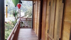 A wooden balcony with a view of a mountainous landscape. - Hoang Hop Homestay - Hostel (Ba Be)