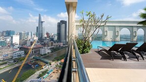 Un balcon offrant une vue sur le paysage urbain, avec notamment une rivière et des bâtiments modernes.