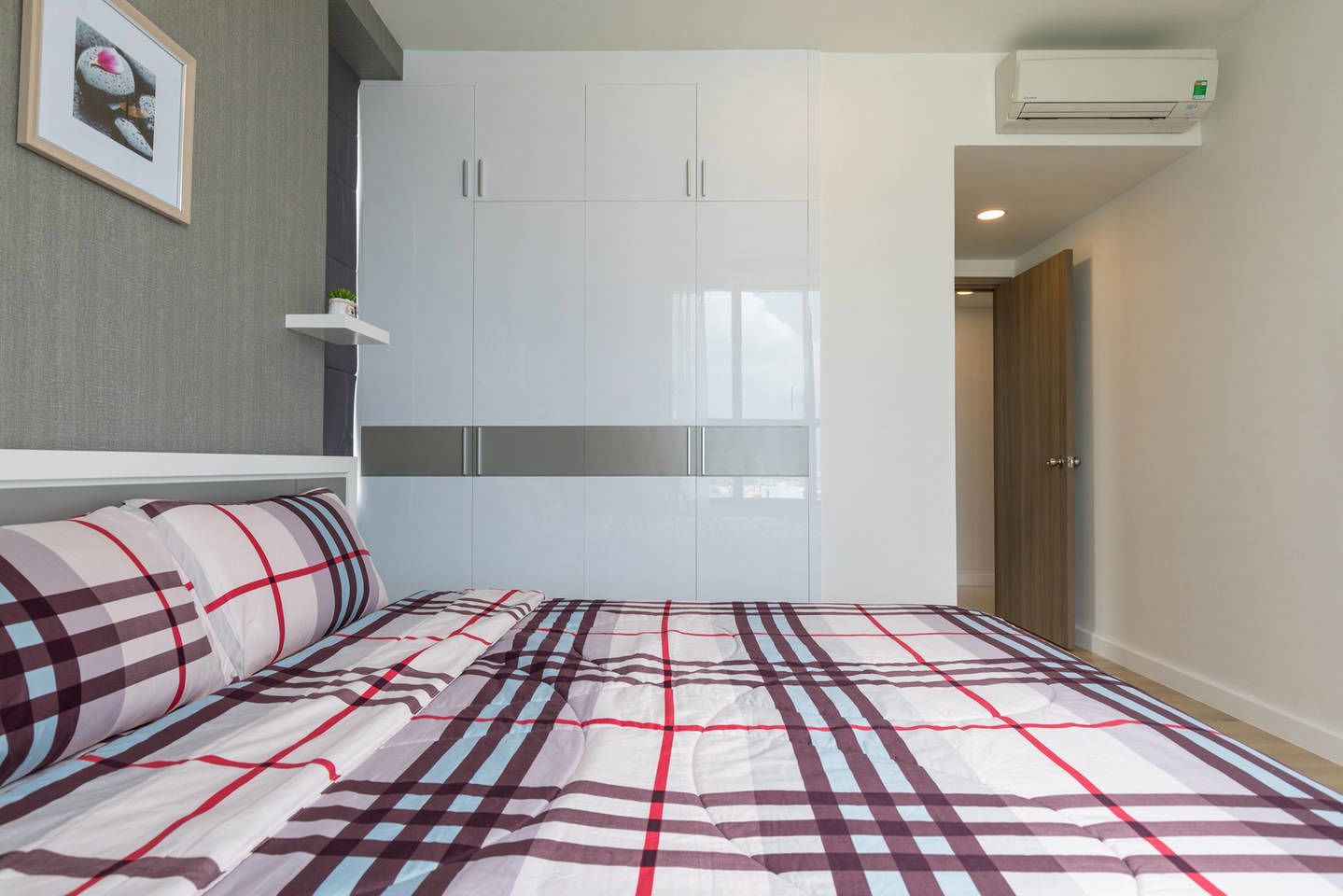 Ein Schlafzimmer mit Bett, Kleiderschrank und Klimaanlage.