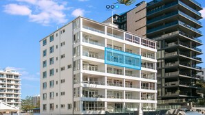Um edifício de vários andares com varandas, janelas amplas e design arquitetônico moderno.