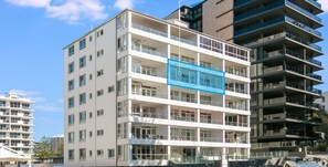 Un immeuble à plusieurs étages doté de balcons, de grandes fenêtres et d’une architecture moderne.