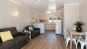 A modern apartment with a living room, kitchen, and dining area.