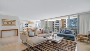 A modern living room with a beige sofa, a blue sofa, and a wooden coffee table.