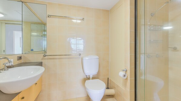 Een badkamer met een wastafel, toilet en douchecabine.