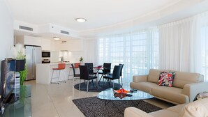 En moderne stue med sofa, sofabord og spiseplads.