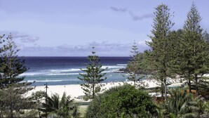 A beach with ocean waves, trees, and a clear sky. - Calypso Plaza Resort Unit 417 Two bedroom unit in resort style complex central Coolangatta (Coolangatta)