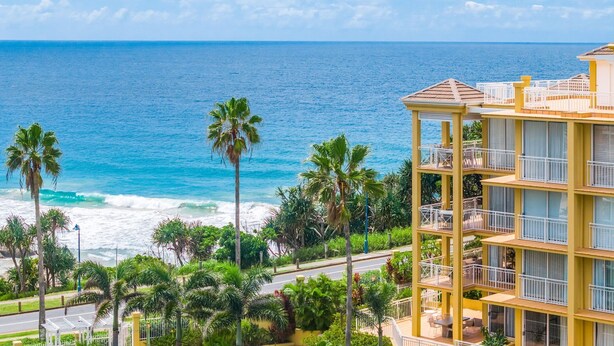 Un hotel de varios pisos con balcones con vistas al océano.