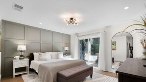 A modern bedroom with a large bed, bedside tables, a bench, and a view of the outdoors. - Urban Elegance in Wine Country: Unwind Just Steps from Healdsburg Plaza! (Healdsburg)