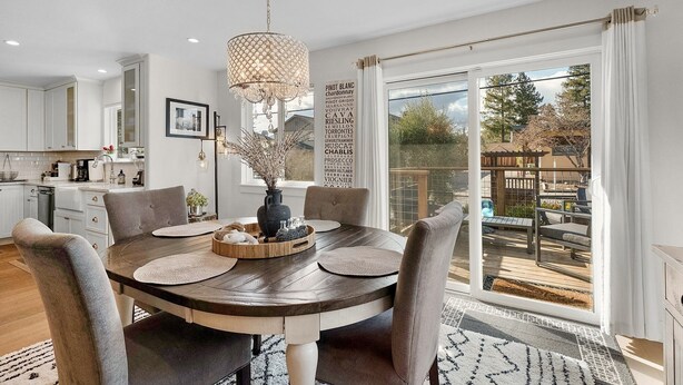 A dining area with a round table, chairs, a chandelier, and a view of the outdoors. - Urban Elegance in Wine Country: Unwind Just Steps from Healdsburg Plaza! (Healdsburg)