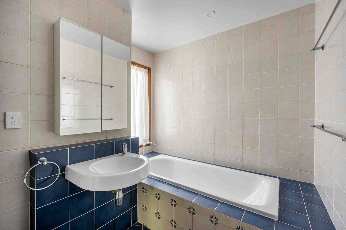 A bathroom with a white sink, a mirror, and a bathtub.