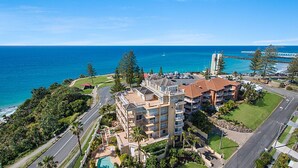 A coastal hotel with multiple balconies, a swimming pool, and a view of the ocean. - Orion Unit 7 Modern apartment with Wi-Fi included, overlooking Snapper Rocks and Rainbow Bay (Coolangatta)