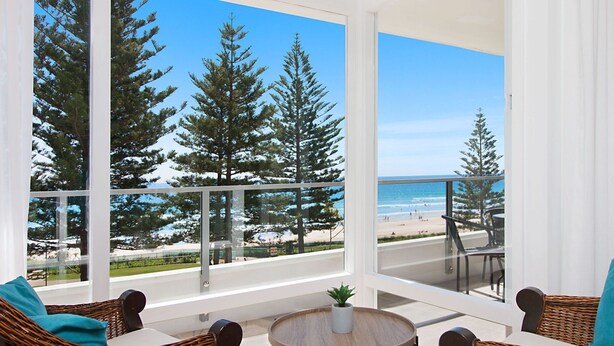 A balcony with a view of the beach and trees. - Rainbow Pacific Unit 9- Stunning views over Rainbow Bay and Snapper Rocks. Swimming Pool. Wi-Fi (Coolangatta)