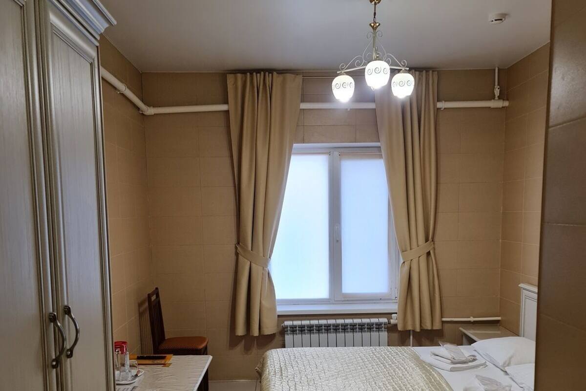 Une chambre à coucher avec un lit, un bureau et un radiateur.