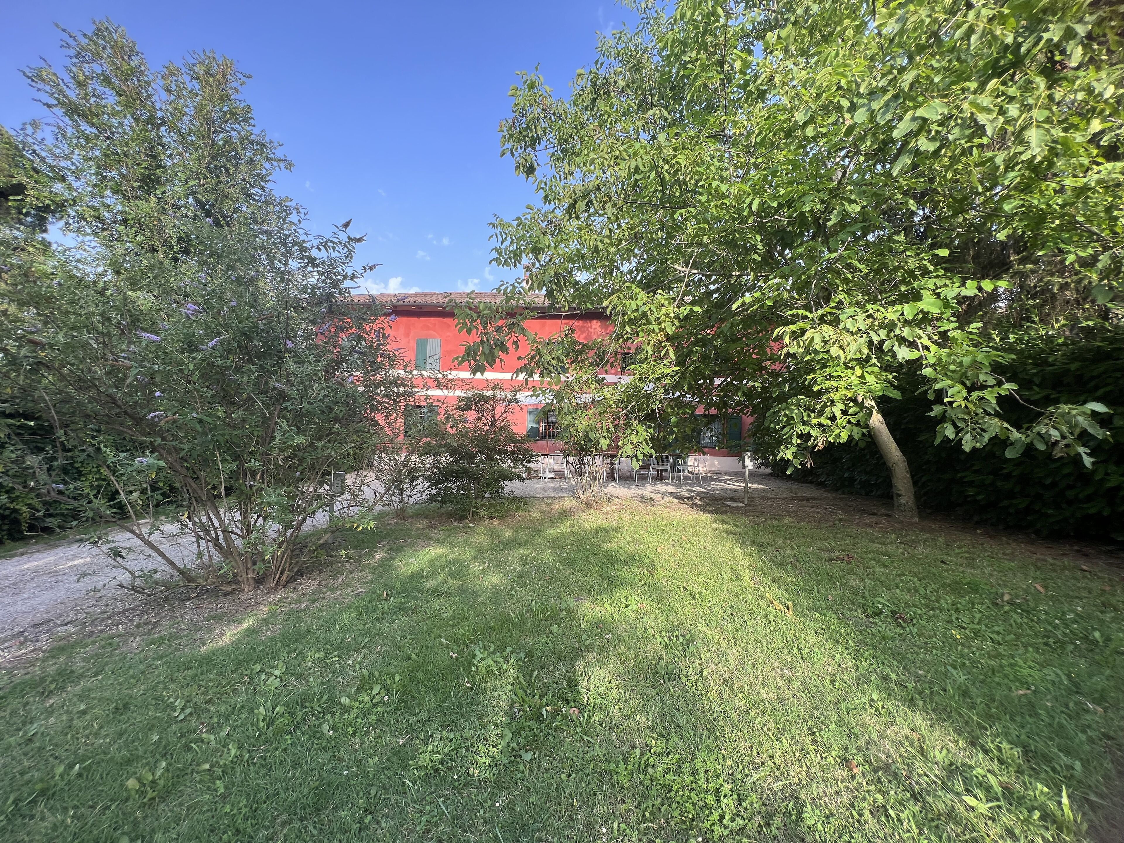 Un bâtiment rouge avec un jardin devant.