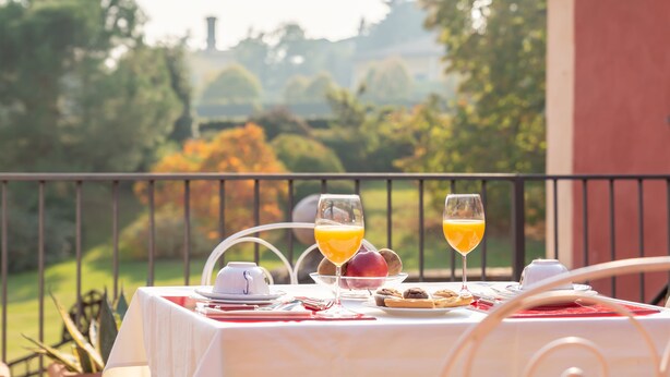 A table set for breakfast with a view of a garden. - Borgo Malvasia- Ca' Palazzo (Sasso Marconi)