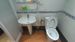 A bathroom with a white sink, a toilet, and a shower. - No.160 7th St. B&B (Ji'an)