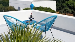 A rooftop terrace with a table, chairs, and a bottle of wine. - B&B La Mia Isola (San Vito Lo Capo)