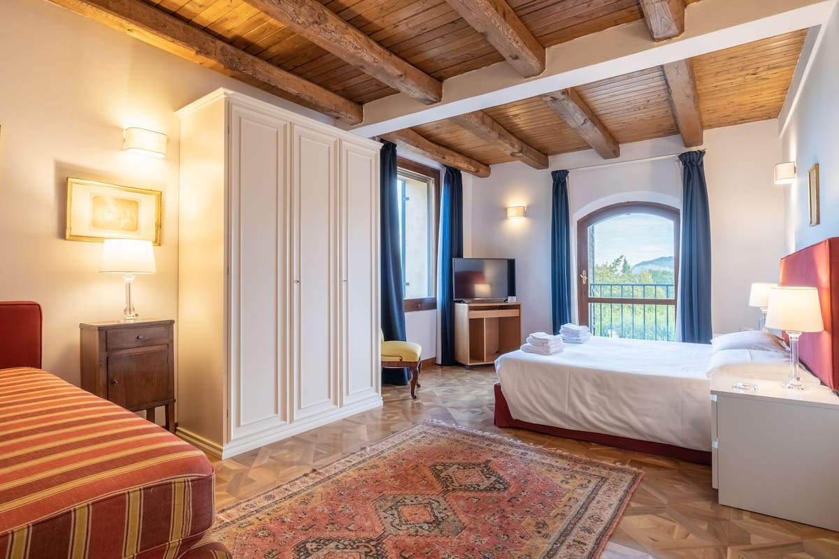 Ein Hotelzimmer mit Bett, Schreibtisch, Fernseher und Blick ins Freie.
