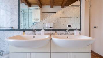 A bathroom with two white sinks, a large mirror, and a wooden ceiling.