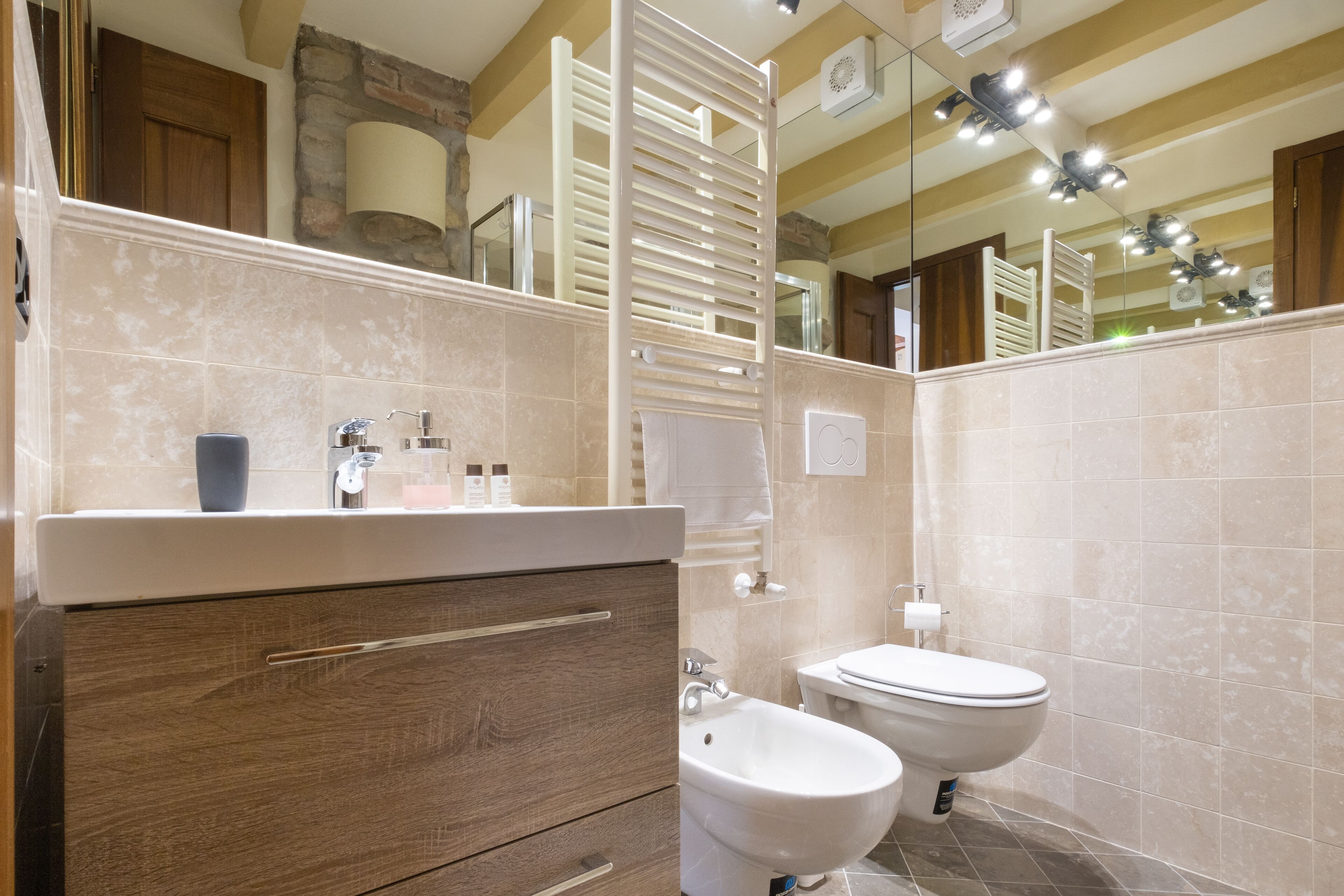 A bathroom with a wooden vanity, two sinks, and a mirror.