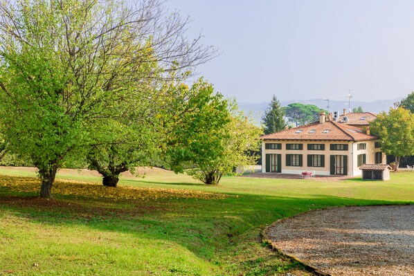 A building with a tiled roof and a garden with trees. - Ca' Malvasia - BolognaRooms (Sasso Marconi)