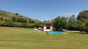 A house with a swimming pool, surrounded by a well-maintained lawn and trees. - Ca' Malvasia - BolognaRooms (Sasso Marconi)