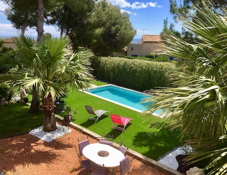 Una piscina al aire libre de temporada, sillones reclinables de piscina