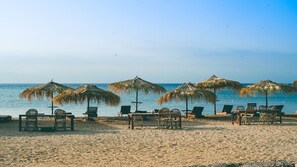 Pantai pribadi, rumah kecil pinggir pantai gratis, dan kursi berjemur