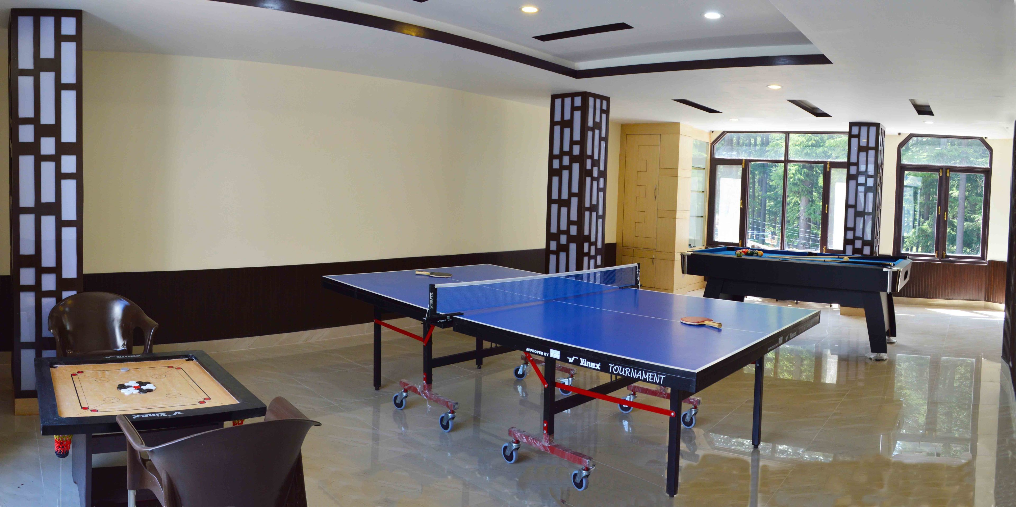 Une pièce équipée d’une table de ping-pong, d’un billard et d’un jeu d’échecs.