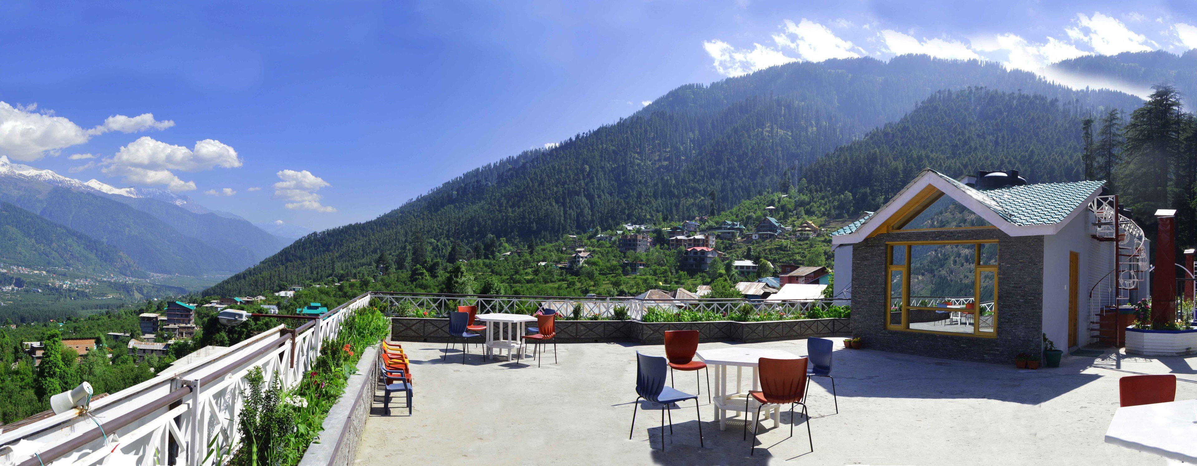 Eine Terrasse mit Sitzgelegenheiten und Blick auf eine Berglandschaft.