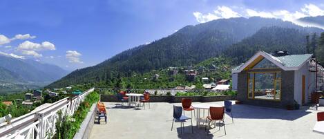 Eine Terrasse mit Sitzgelegenheiten und Blick auf eine Berglandschaft.