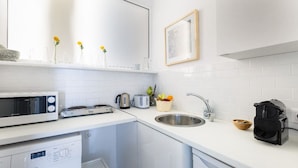 A compact kitchen with a microwave, toaster, kettle, and coffee maker. - Parthenon Apartment (Athens)
