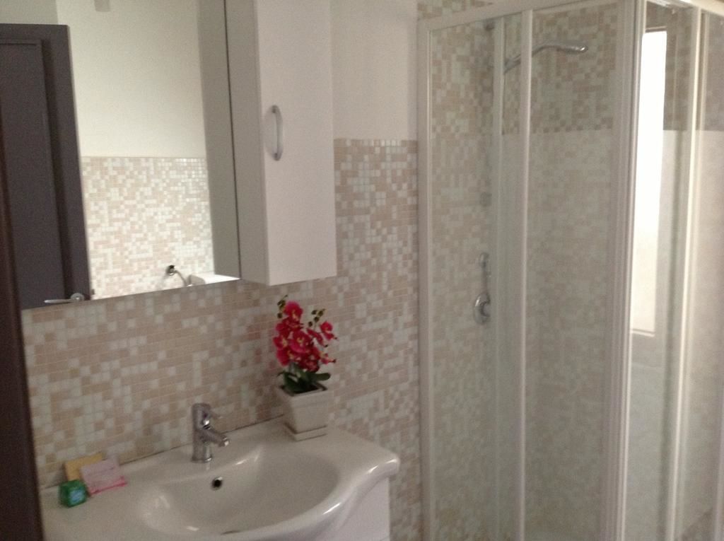A bathroom with a sink, mirror, and shower.