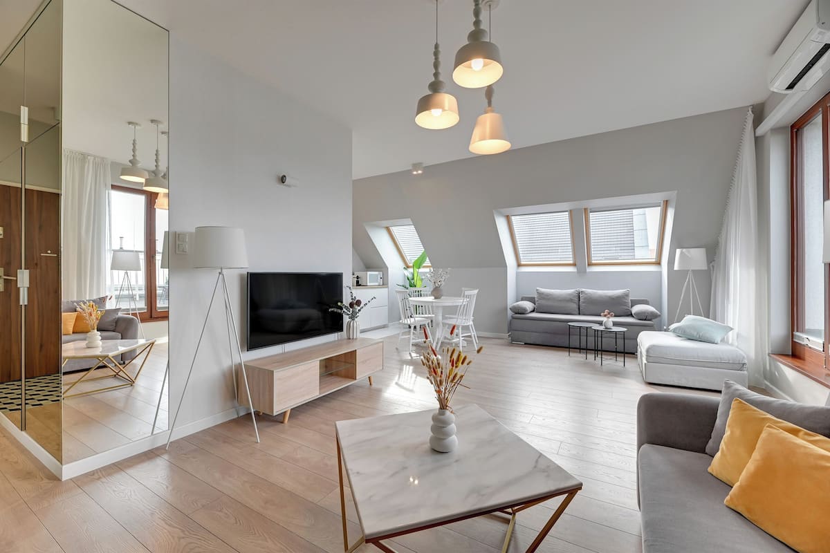 A modern living room with a TV, sofa, and dining area.