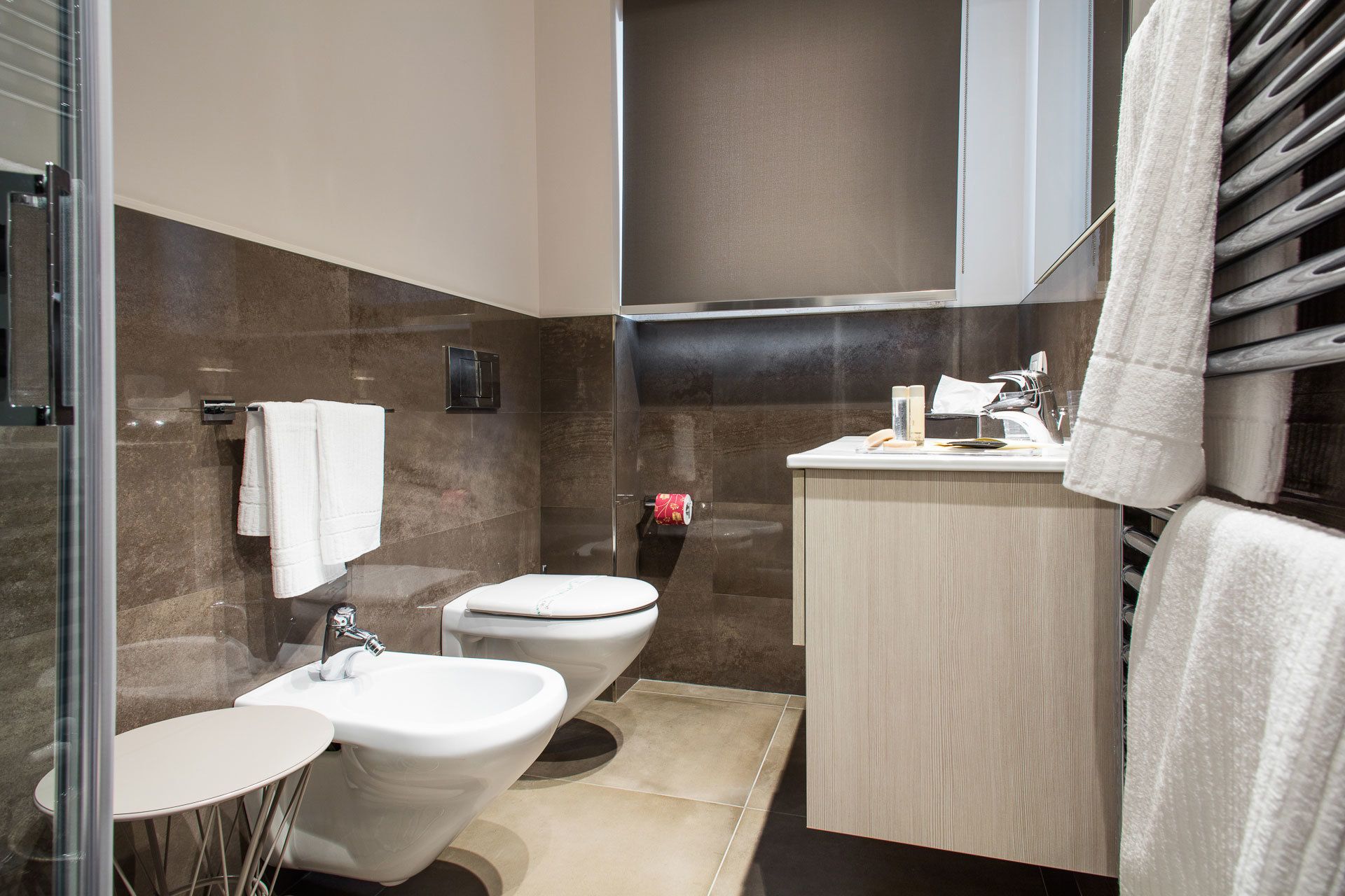 Une salle de bain moderne équipée d’un bidet, de toilettes, d’un lavabo et d’un meuble-lavabo.