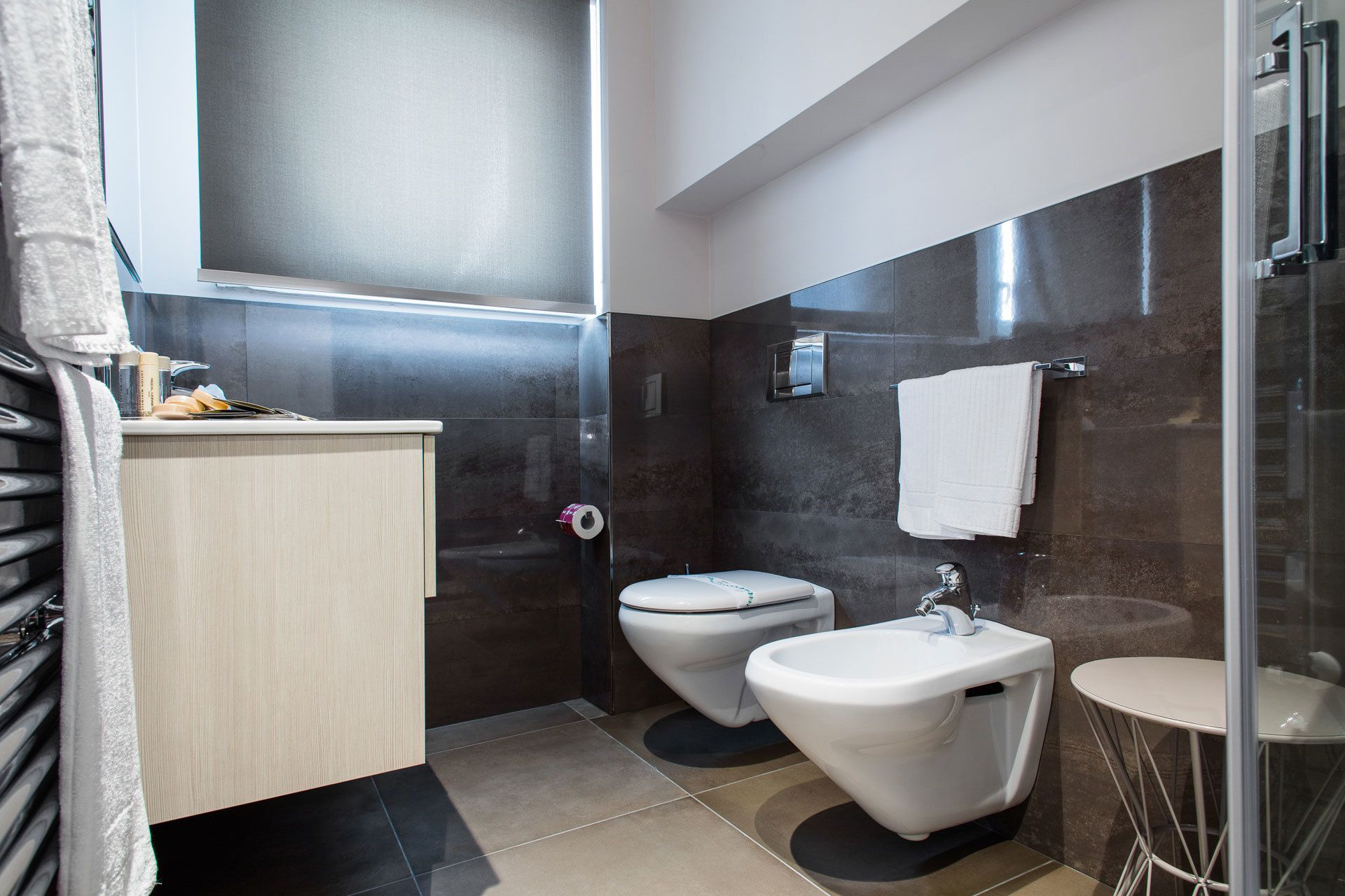 A modern bathroom with a toilet, bidet, and sink.
