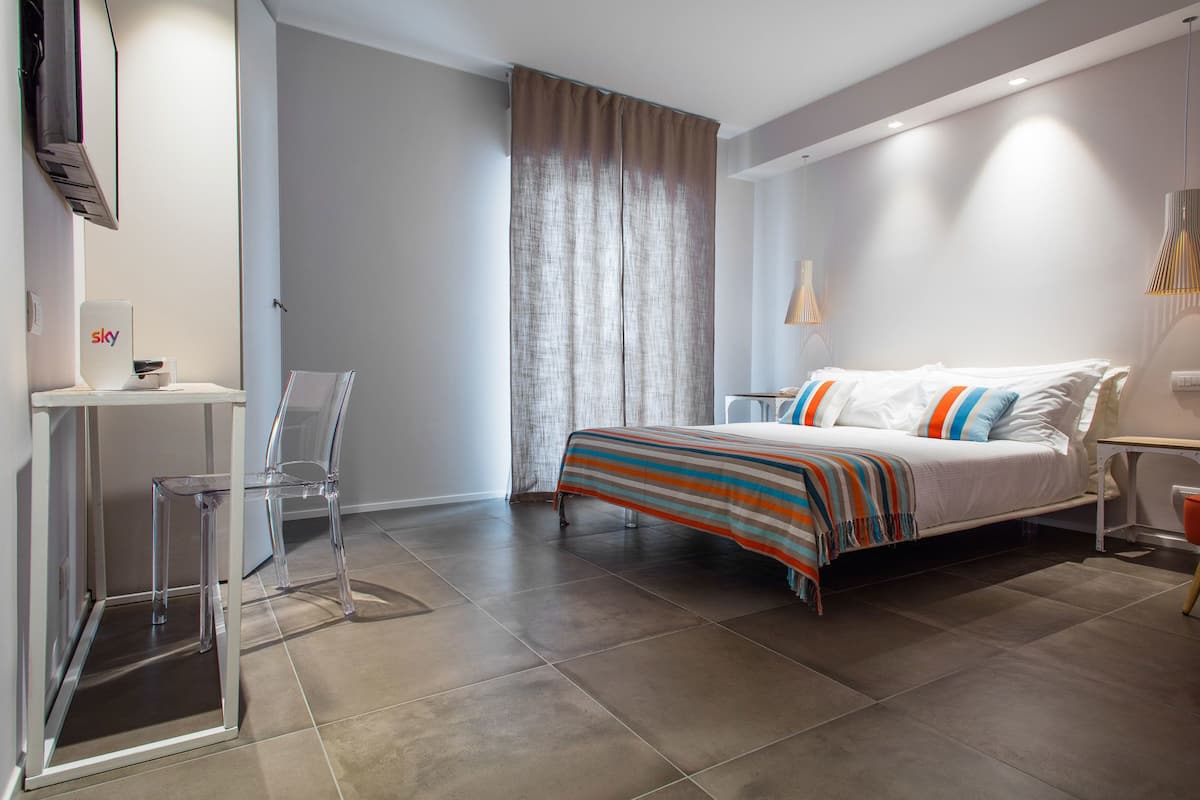 A modern bedroom with a bed, a desk, and a chair.