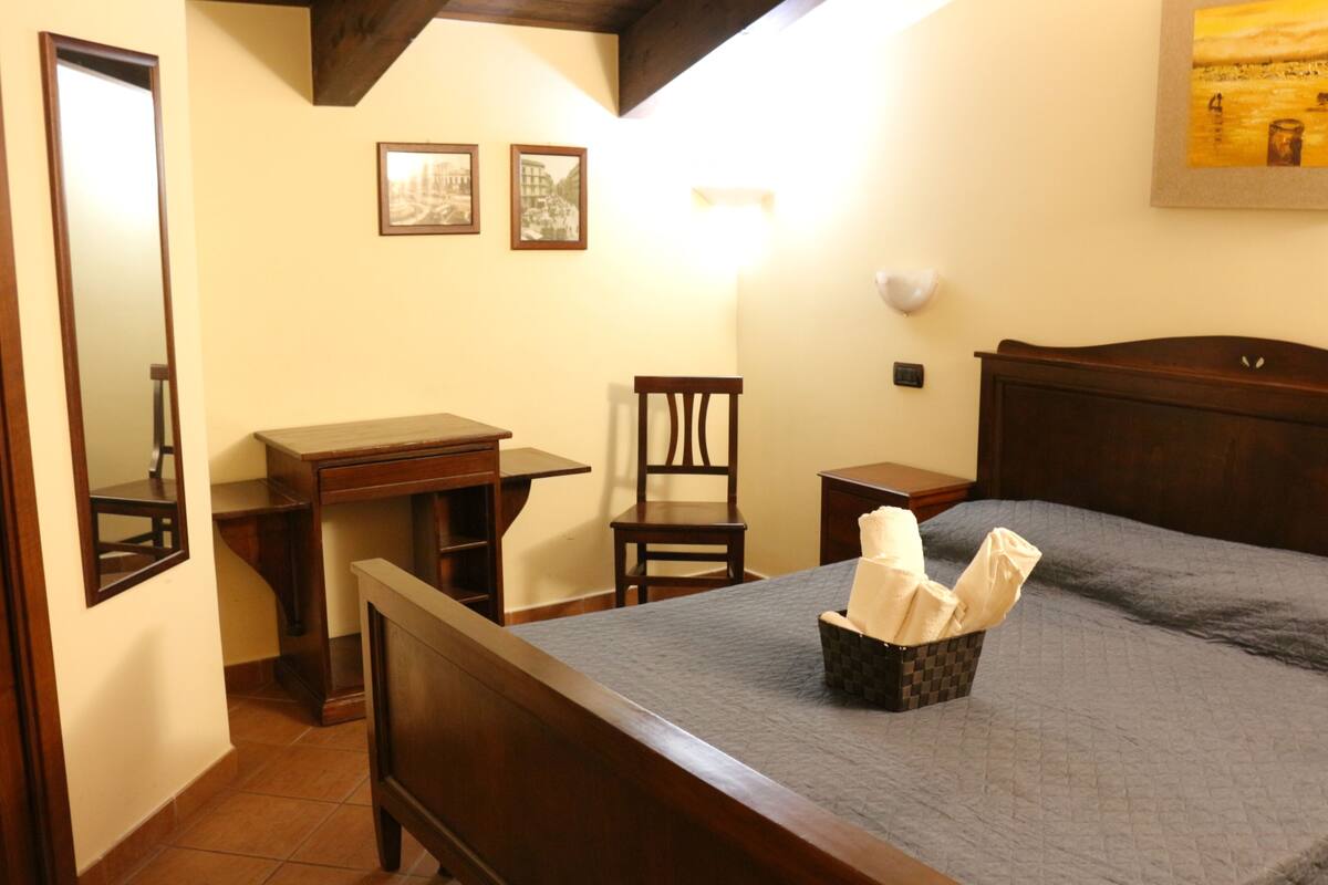 Ein Schlafzimmer mit Bett, Schreibtisch, Stuhl und Nachttisch.